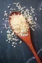 A detailed view of raw sugar cubes on a wooden spoon over a dark surface.